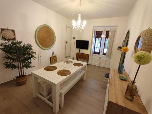 ein Wohnzimmer mit einem weißen Tisch und einem TV in der Unterkunft L'Arco Verde in Trabia