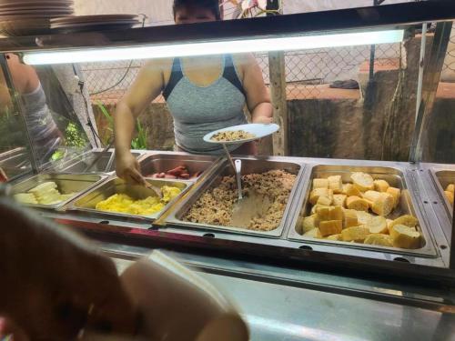 a woman is preparing food in a buffet at Downtown Montezuma Hostel in Montezuma