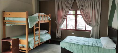 a bedroom with two bunk beds and a window at Cozy Room, private bathroom, views of mountains kitchen in Huaraz