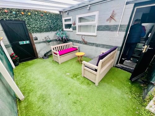 a small backyard with two chairs and a table at Winter Gardens large modern home in Blackpool