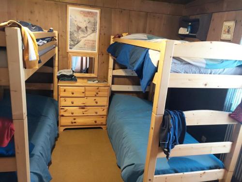 a room with two bunk beds and a dresser at Chalet La Gayolle - Chalets pour 12 Personnes 96 in Saint-Gervais-les-Bains