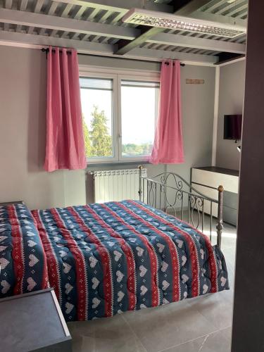 a bedroom with a bed with a red and blue blanket at Casa vista mare in Corsanico-Bargecchia