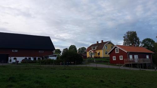 a group of houses and a yellow and red house at Älgbergets Bed & Breakfast in Ucklum