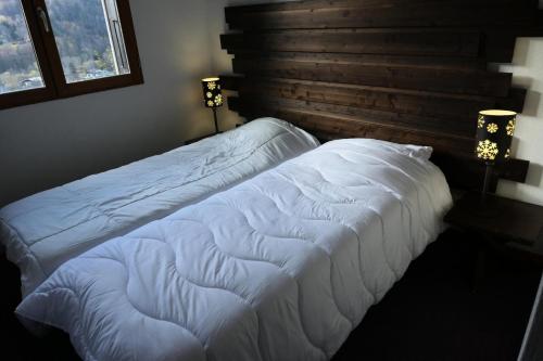 Duas camas brancas num quarto com uma janela em Résidence Les Fermes De Saint Gervais - 3 Pièces pour 6 Personnes 20 em Saint-Gervais-les-Bains