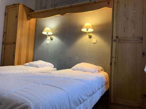 - 2 lits dans une chambre avec 2 lampes sur le mur dans l'établissement Résidence Le Grand Panorama - Grand Panorama 001 MAE-5280, à Saint-Gervais-les-Bains