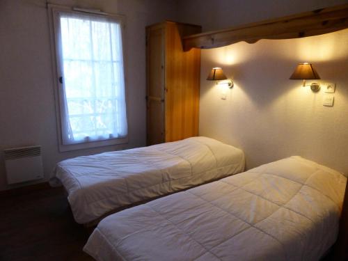 een hotelkamer met 2 bedden en een raam bij Résidence Le Grand Panorama - 2 Pièces pour 4 Personnes 83 in Saint-Gervais-les-Bains