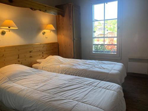 deux lits dans une chambre d'hôtel avec une fenêtre dans l'établissement Résidence Le Grand Panorama - Grand Panorama 202 MAE-5294, à Saint-Gervais-les-Bains