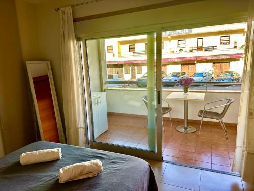 a room with a bed and a view of a balcony at Charming 3 bedroom apartment in Playa de San Juan