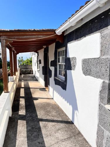 a house with a white wall and a doorway at Casa da Olivia in Lajes do Pico