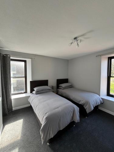 duas camas num quarto com duas janelas em Argyle House Wick em Wick