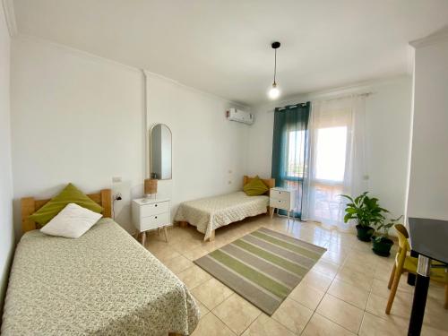 a small bedroom with two beds and a window at Delight City Apartment in Kavajë