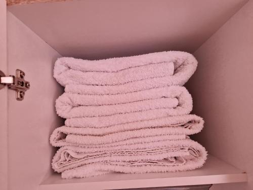a pile of towels are stacked on a shelf in a bathroom at La casa de los viajeros in Vevey