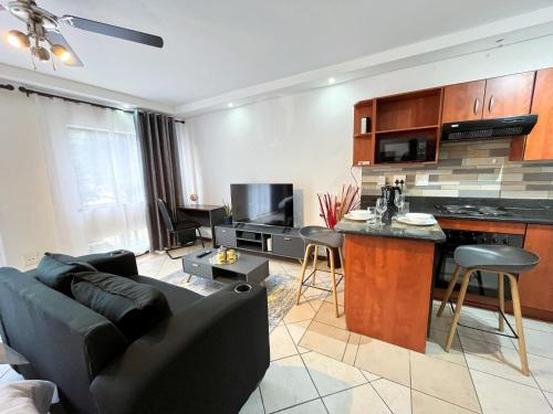 ein Wohnzimmer mit einem Sofa und einer Küche in der Unterkunft La Place 56 in Pretoria