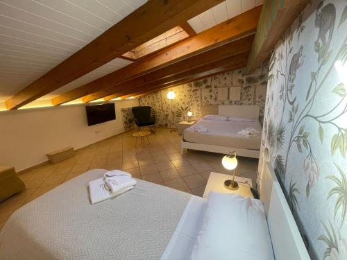 a bedroom with two beds and a tv in a room at Albergo Perseo in Portopalo