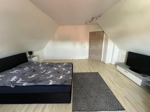 Schlafzimmer mit einem Bett und einem Flachbild-TV in der Unterkunft 2,5 Raum Ferienwohnung möbliert Dachgeschoss Niederorschel in Niederorschel