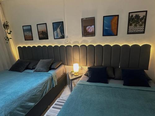 2 camas en una habitación con fotos en la pared en Loft com vista lateral para o mar, en Río de Janeiro