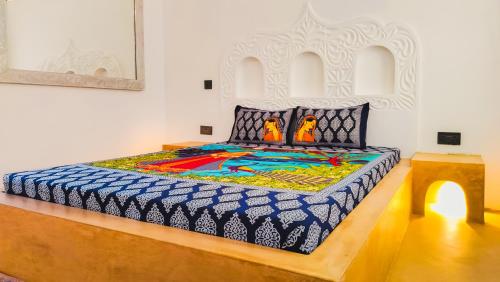 a bedroom with a large bed with a colorfulspread at Casa Maridadi in Watamu