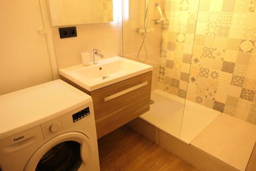 a bathroom with a washing machine and a sink at Résidence Amethyste - 2 Pièces pour 4 Personnes 334 in Saint-Gervais-les-Bains