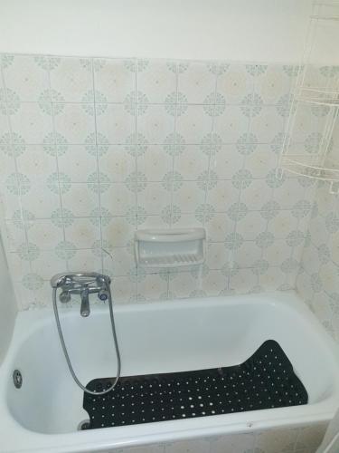 a bath tub with a black seat in a bathroom at Pace tra gli ulivi e il mare in Sori