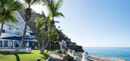 a resort with palm trees and the ocean at TUI BLUE Suite Princess - Adults Only in Taurito