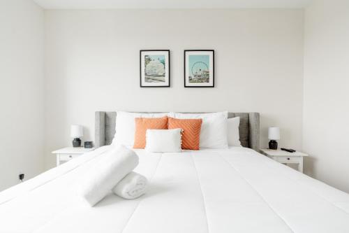 uma cama branca com almofadas laranja e branca em Desing district, great apartment em Miami