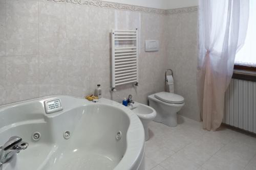 a bathroom with a white tub and a toilet at LA VELA in Negrar