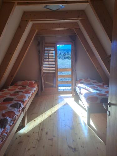 two beds in a room with a window at Gorska vila in Žabljak