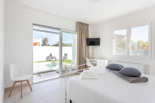 Habitación blanca con cama y ventana en Villa Greca Holiday Rooms, en Sant' Isidoro