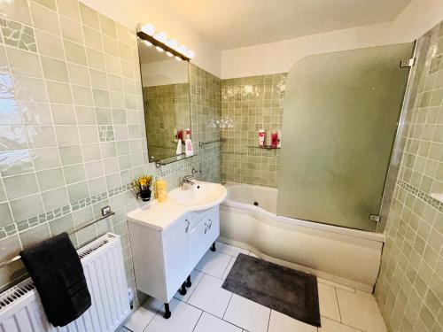 a bathroom with a sink and a bath tub at The European 3 Bedroom House By AltoLuxoExperience Short Lets & Serviced Accommodation With Free Parking in Bristol