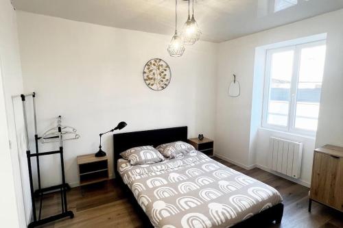 une chambre blanche avec un lit et une fenêtre dans l'établissement Appartement spacieux chaleureux, à Roanne