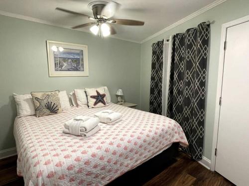 een slaapkamer met een bed met twee handdoeken erop bij Crashin' Waves-Oceanview Bikes and King Bed in Hilton Head Island
