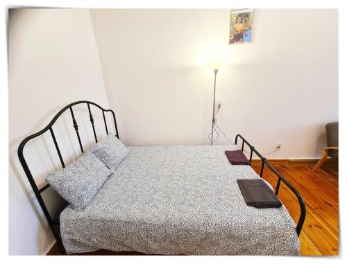 Łóżko w małym pokoju z lampką w obiekcie SouvenirAppart Sniadeckich 45 w Bydgoszczy
