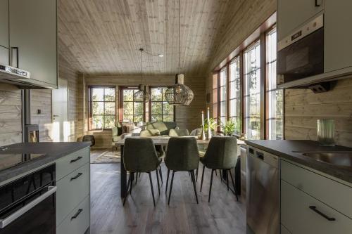 a kitchen with a table and chairs and a living room at Parkstigens Fjällby - Kåvan in Funäsdalen