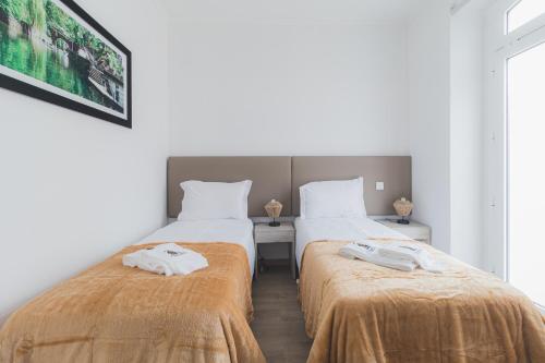 two beds with orange blankets in a room at Lousã Estação AL in Lousã