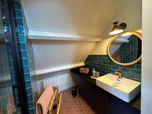 La salle de bains est pourvue d'un lavabo et d'un miroir. dans l'établissement A l’ombre des chênes, à Coye-la-Forêt