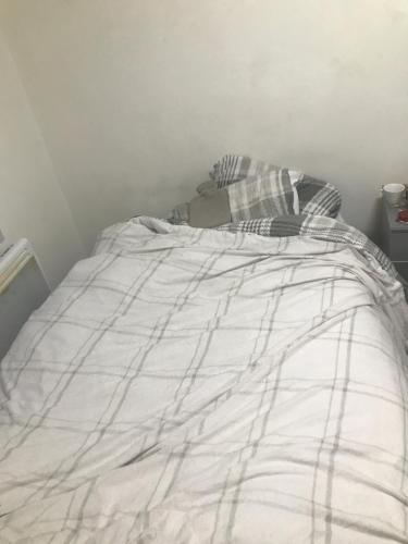 een bed met een deken erop bij Luxx apartment in Erith