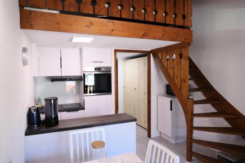 une cuisine avec un escalier menant à un loft dans l'établissement Résidence Hameau De Coterat - Hameau de Coterat 11 MAE-2524, à Saint-Gervais-les-Bains