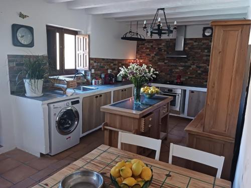 a kitchen with a table with a bowl of fruit at Casa rural los Cerezos in Albox