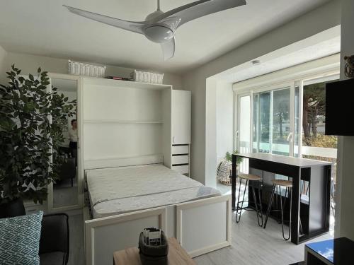 - un salon avec une table et un ventilateur de plafond dans l'établissement Studio 25m2, 4 pers cosy, design, avec parking privé, à La Grande Motte