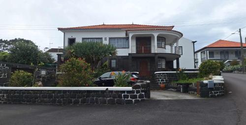 a large house with a stone wall in front of it at Casa da Furna in Santo António