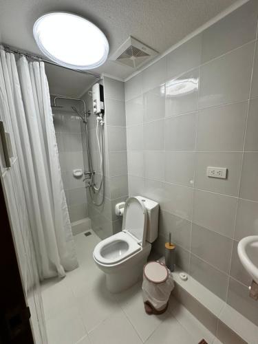 y baño con aseo, ducha y lavamanos. en Resort-inspired Condo with Queen-size bed & 50-inch Smart TV, en Cebú