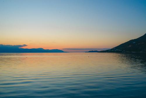 a sunset over a large body of water at CiTYZen Hotel in Loutraki