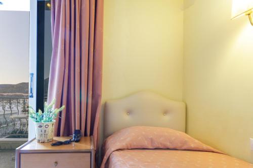 a bedroom with a bed and a table and a window at CiTYZen Hotel in Loutraki