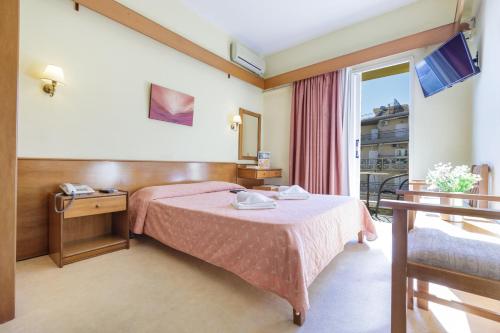 um quarto de hotel com uma cama e uma janela em CiTYZen Hotel em Loutraki