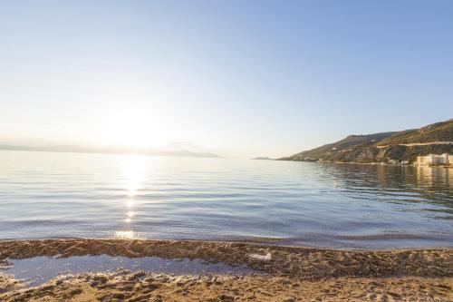 a view of a body of water with the sun shining at CiTYZen Hotel in Loutraki