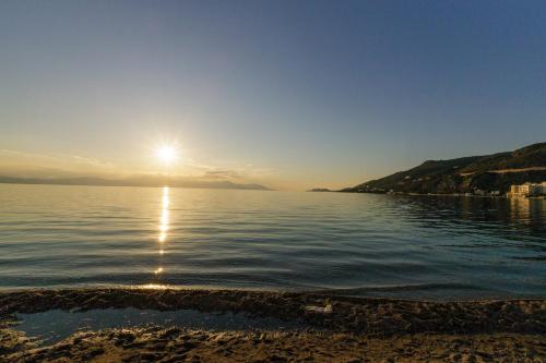 a sun setting over a body of water at CiTYZen Hotel in Loutraki
