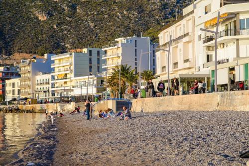 a group of people on a beach near the water at CiTYZen Hotel in Loutraki