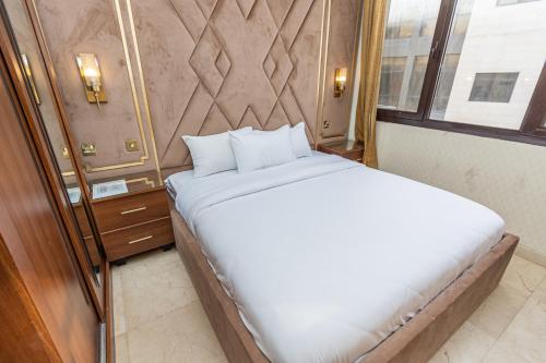 a large white bed in a room with a window at Rihanna Hotel Apartment in Kuwait
