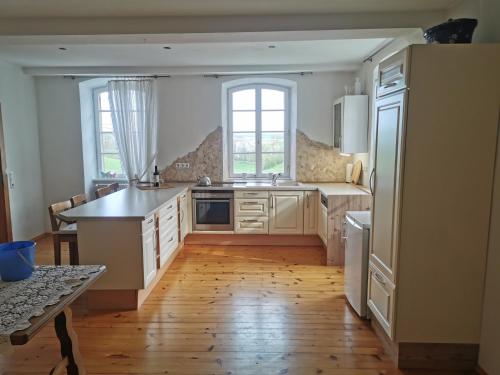 een keuken met witte kasten en een houten vloer bij Ferienwohnungen Stuppacher Hof in Hornbach