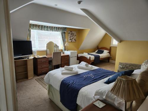 サウサンプトンにあるThe Mayfair guest house self cateringのベッド2台とデスクが備わるホテルルームです。